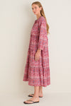 A woman models the Americana Batik Stripe Long Sleeve Salty Paloma Caftan, a classic, effortless, high-end dress with floral print, perfect for warm weather getaways.