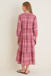 Back view of a woman in a classic, effortless Americana Batik Stripe Long Sleeve Salty Paloma Caftan, showcasing its tiered design and bohemian flair.