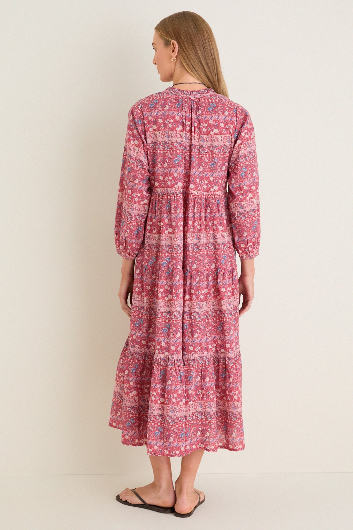 Back view of a woman in a classic, effortless Americana Batik Stripe Long Sleeve Salty Paloma Caftan, showcasing its tiered design and bohemian flair.