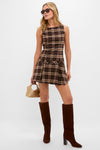 Woman models effortlessly chic Flame Berlin Sunglasses with classic rectangular frame, paired with a plaid mini dress and high-end suede boots, embodying fun sophistication.