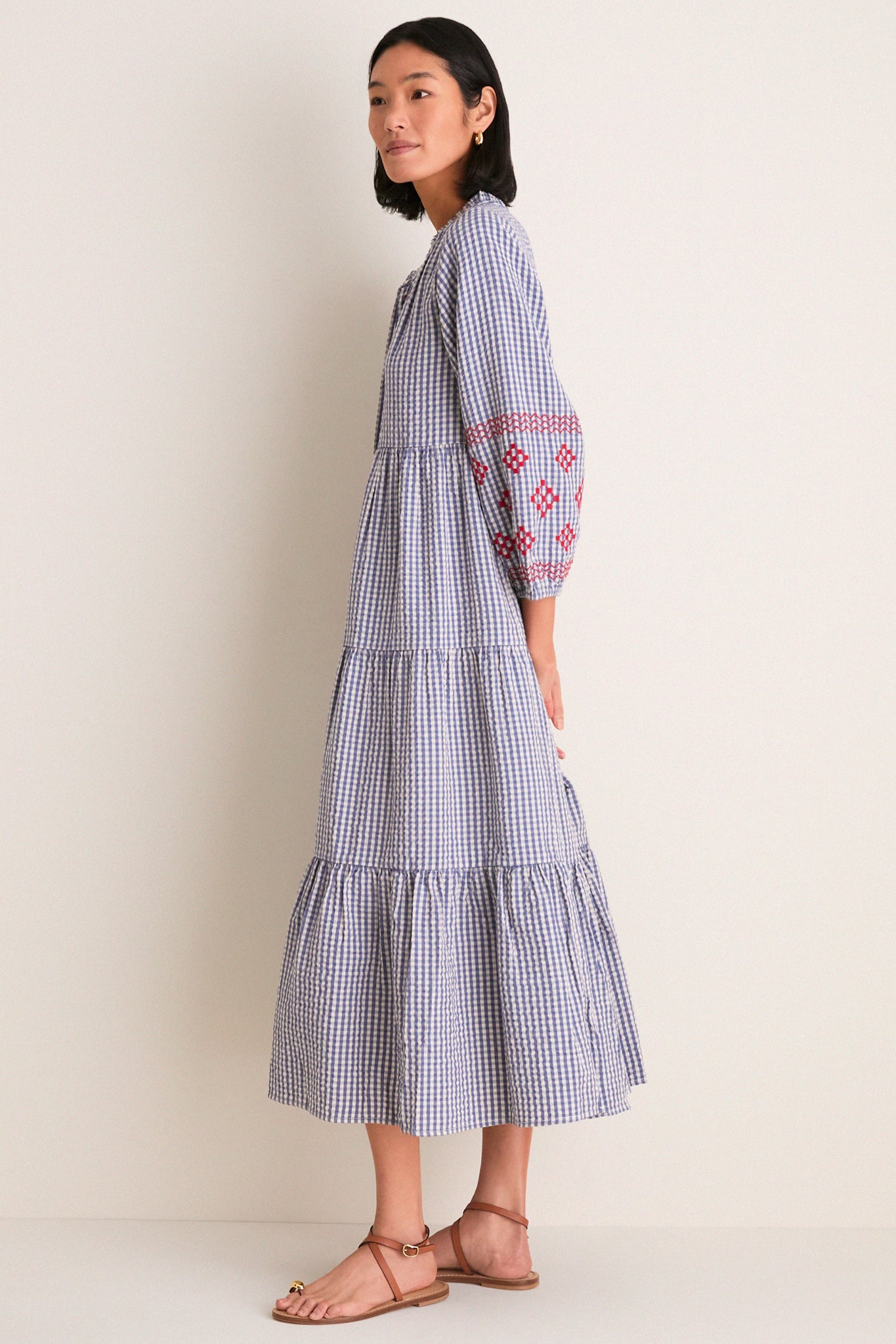 Woman in profile wearing the Navy Prism Embroidered Gingham Long Sleeve Salty Paloma Caftan, a classic, effortless, and high-end Tuckernuck piece with fun embroidered details.