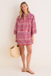 Woman in classic Americana Batik Stripe Bondi Coverup, featuring effortless floral print, tassel ties, and fringed hem. Styled with fun accessories for a high-end beach look.