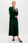 Woman modeling the classic Green Velvet Serena Dress, featuring effortless balloon sleeves, a fitted waist, and a high-end diagonal button placket, styled with fun heels.