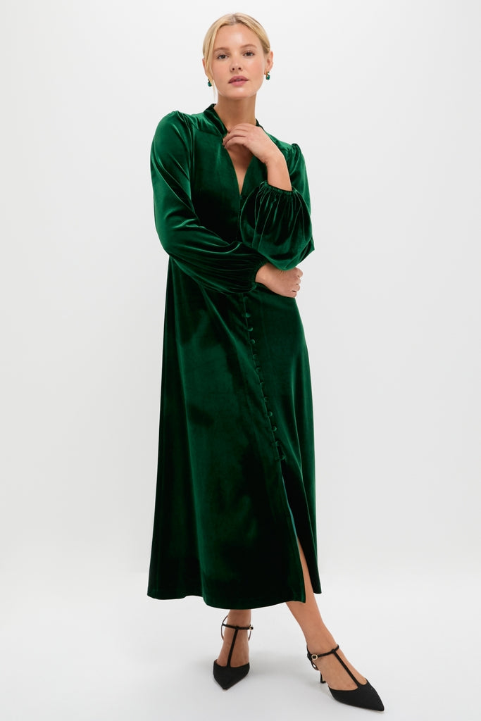 Woman modeling the classic Green Velvet Serena Dress, featuring effortless balloon sleeves, a fitted waist, and a high-end diagonal button placket, styled with fun heels.