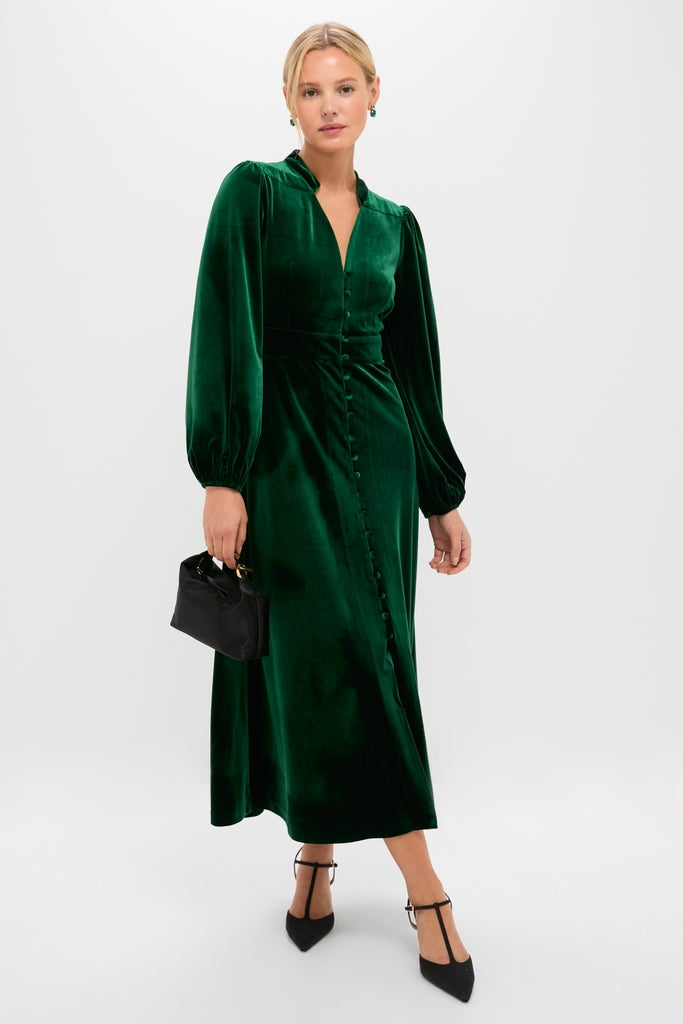 The Green Velvet Serena Dress exudes classic elegance, featuring long balloon sleeves, a fitted waist, and a front button placket, paired effortlessly with chic black heels.