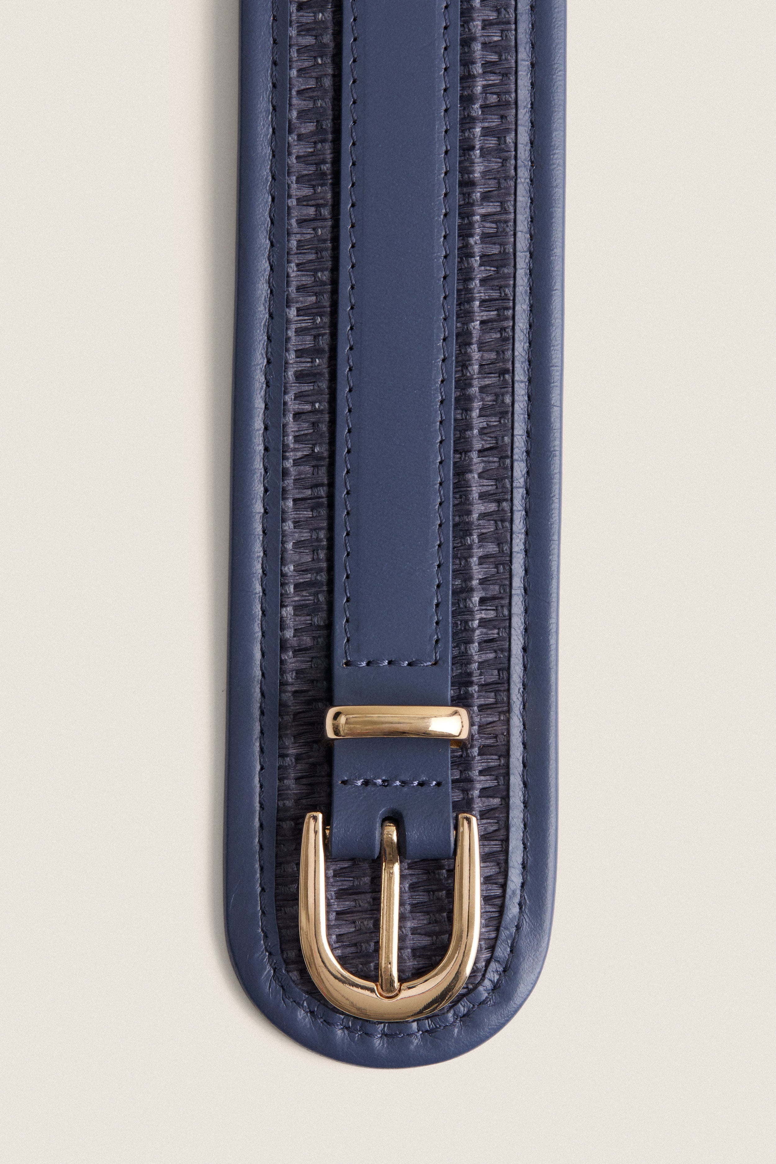 Navy Raffia Waist Belt with classic woven detailing, leather trim, and high-end gold-tone buckle, effortlessly cinches waists for a fun, flattering look.