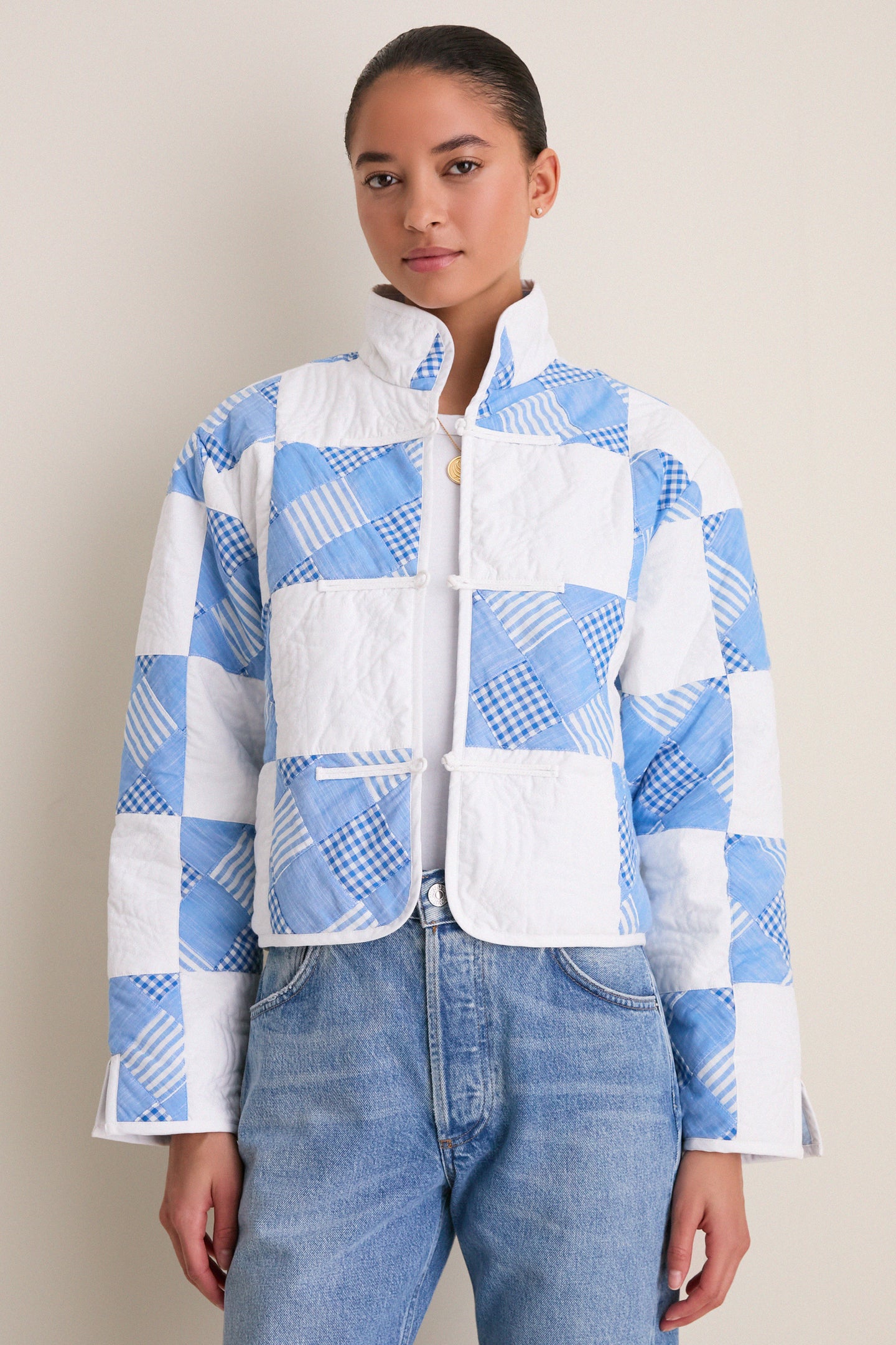 Model in Blue and White Quilted Cropped Townley Jacket, featuring classic patchwork, paired with light-wash jeans and a gold necklace for an effortless, high-end look.