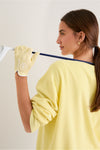 Young woman holds a golf club, showcasing a classic, high-end Yellow Left Hand Golf Glove. Effortless style meets fun functionality for the perfect swing.