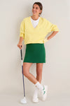 Young woman in classic golf attire showcases the Yellow Left Hand Golf Glove, blending effortless style and fun with high-end functionality for a confident swing.