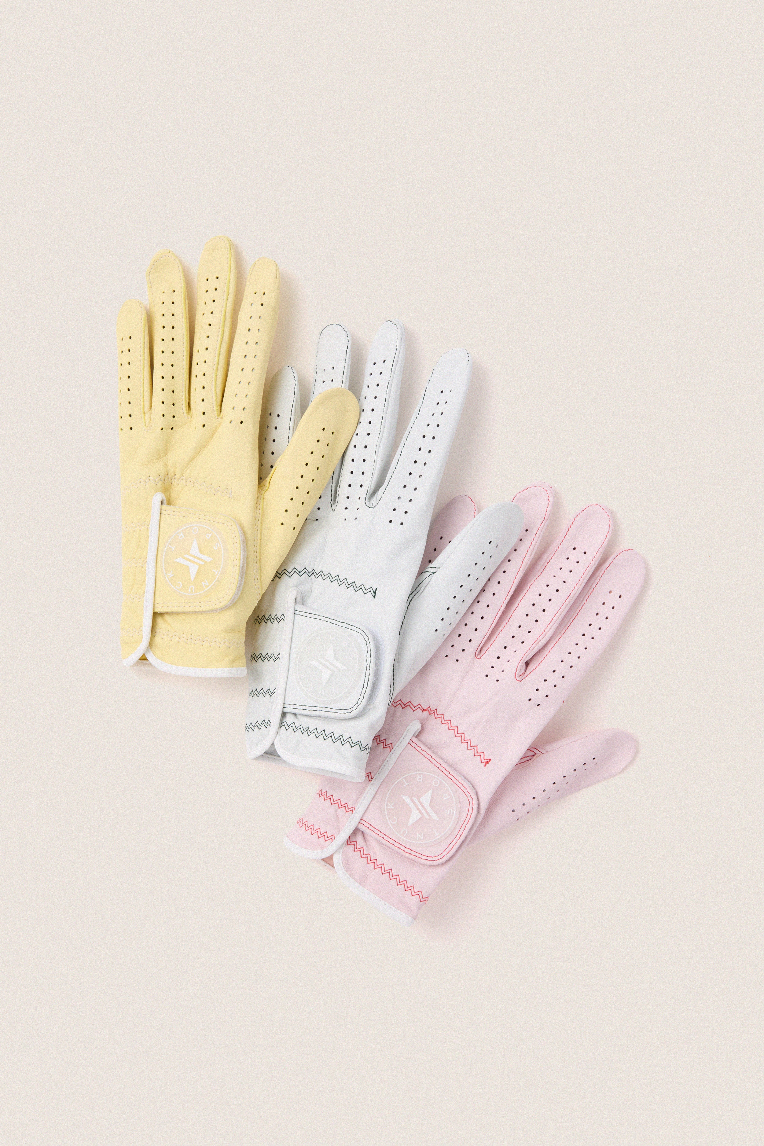 White Left Hand Golf Glove: classic, perforated leather design with a velcro strap, featuring Tuckernuck's logo. Effortless, fun, and high-end, enhancing your swing.