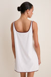 Woman in an effortless, high-end Blanc Shell Embroidered Terrycloth Dress Coverup, featuring classic brown trim and fun shell motifs on front pockets.