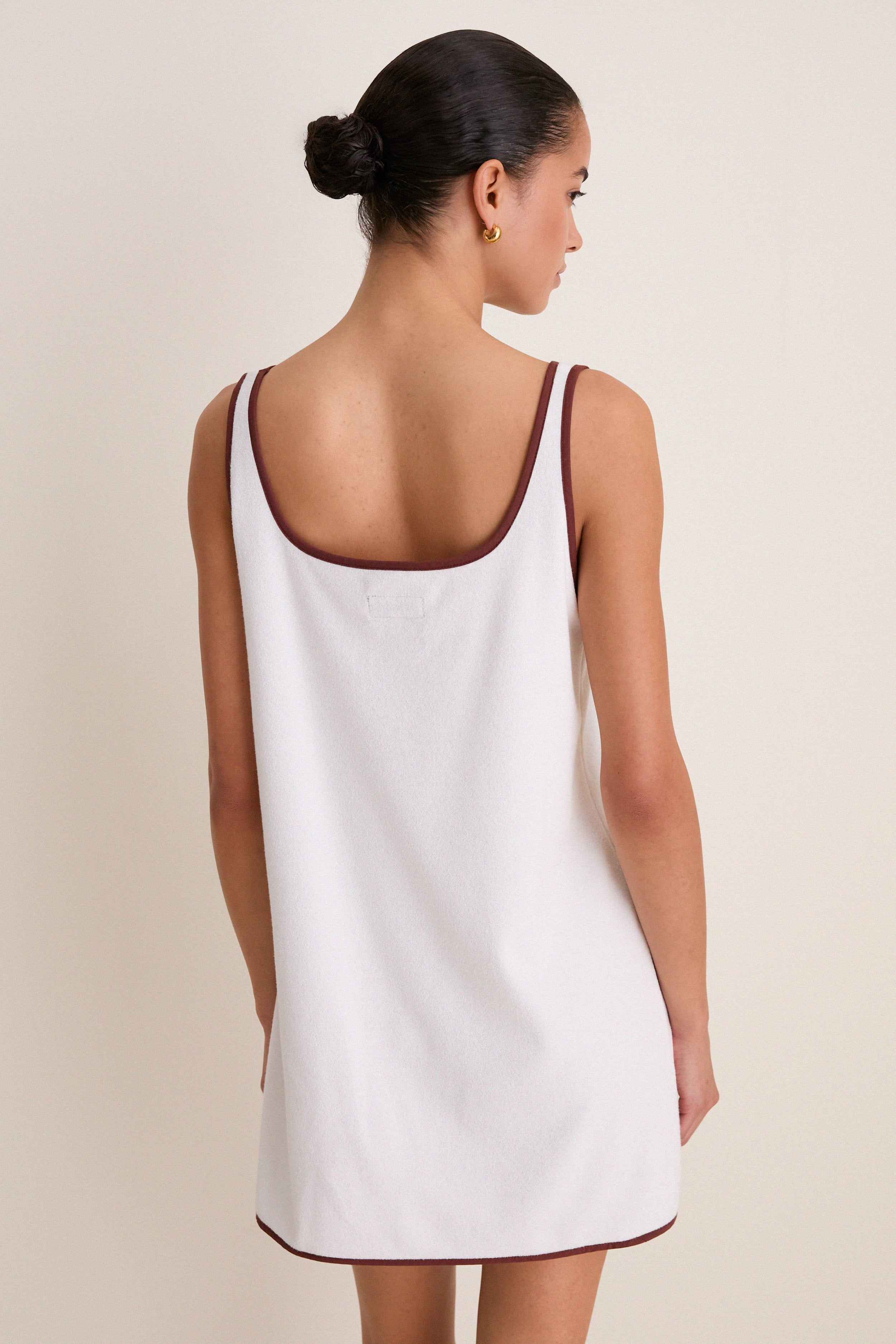 Woman in an effortless, high-end Blanc Shell Embroidered Terrycloth Dress Coverup, featuring classic brown trim and fun shell motifs on front pockets.