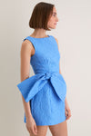 Young woman models the Blue Jacquard Briallen Bow Mini Dress, featuring a classic boat neckline, sleeveless design, and an oversized bow, exuding effortless, high-end elegance.