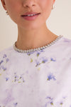 Close-up of a classic, sparkly tennis necklace complementing the Lilac Floral Crystal Embellished Floria Mini Dress with a fun, effortless, high-end vibe.