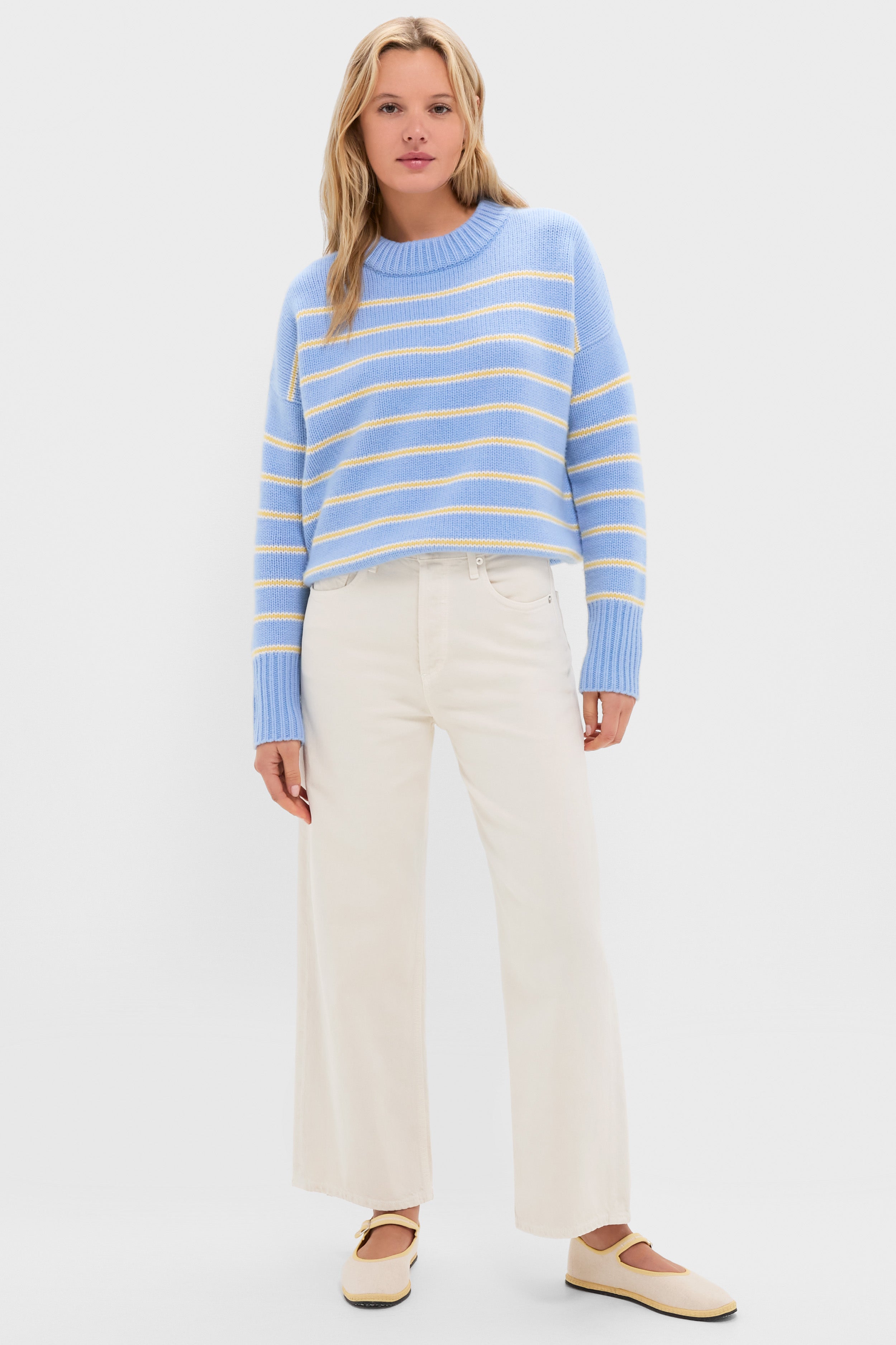 Young woman in a classic, high-end Chambray, Butter and Cream Fineline Stripe Marin Sweater, showcasing effortless style with fun, relaxed fit and ribbed details.
