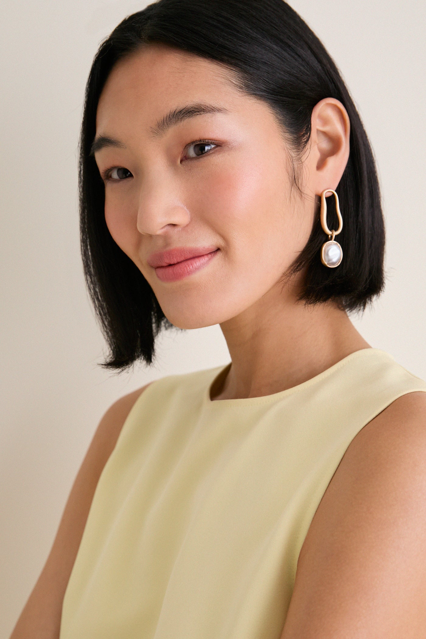 Young woman models the Butter Maxime Top, a classic, sleeveless design with a crew neckline. Effortless and high-end, it’s perfect for a fun, polished look.