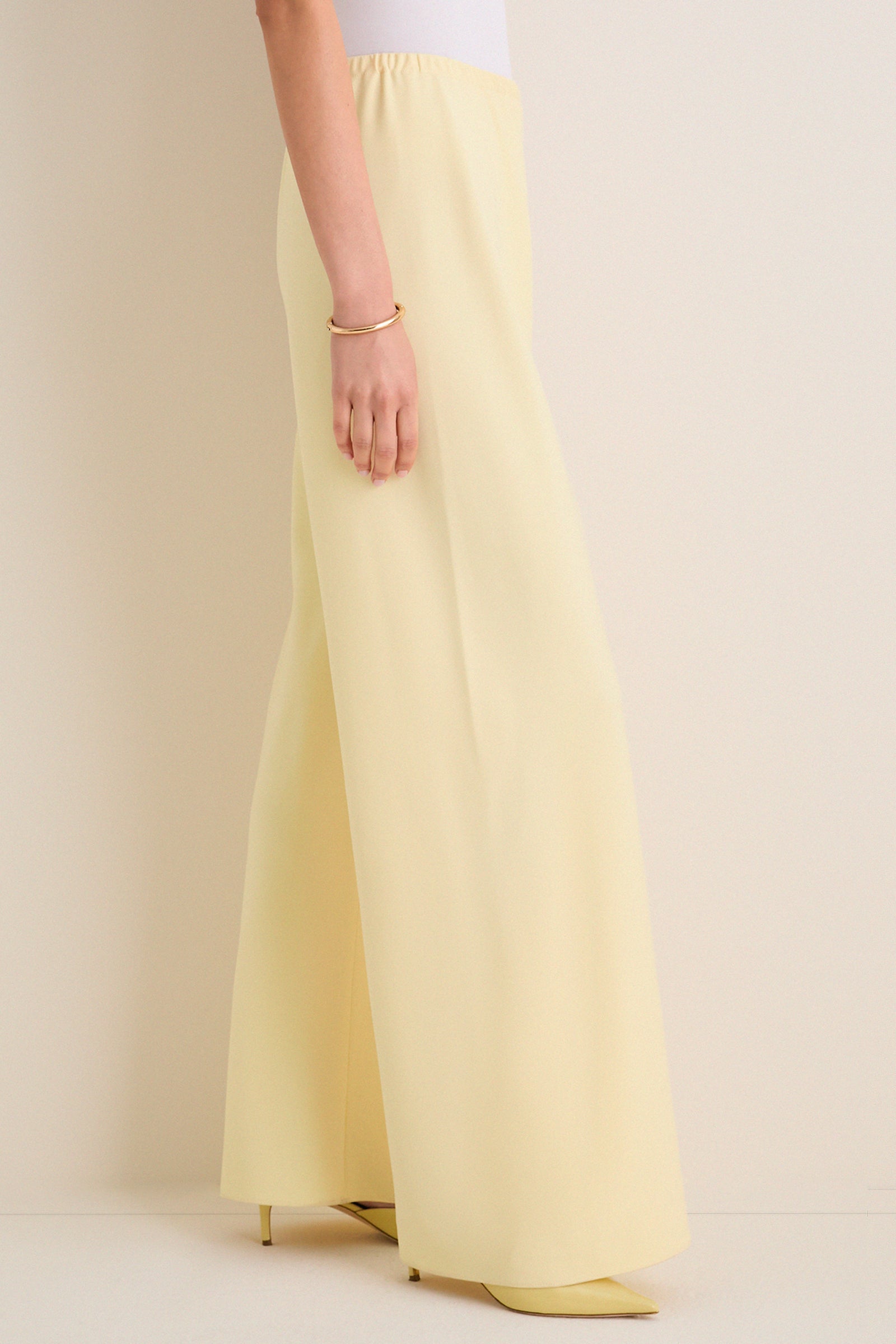 Model showcasing classic, high-end Butter Crepe Colby Pant with effortless wide-leg design, elastic waistband, and matching heels, epitomizing fun, elevated style.