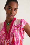 Young woman models the Pink Holy Snake Mini Sasha Dress, a classic boho chic piece with ruffled sleeves, a vibrant print, and an effortless, high-end, fun style.