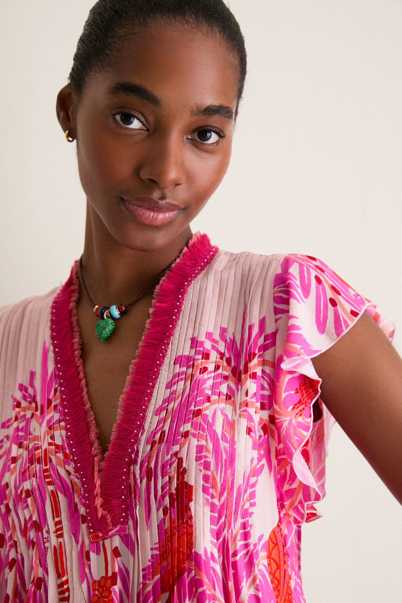 Young woman models the Pink Holy Snake Mini Sasha Dress, a classic boho chic piece with ruffled sleeves, a vibrant print, and an effortless, high-end, fun style.