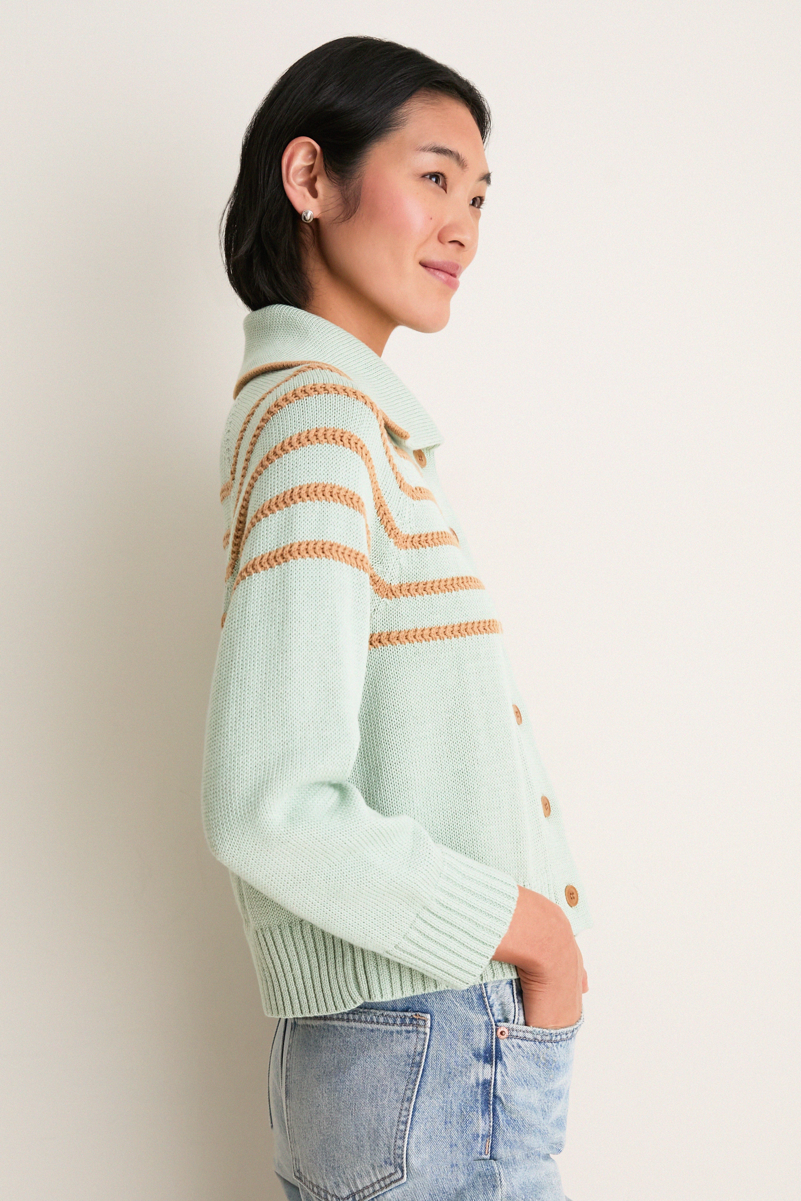 Young woman in profile wearing the Seafoam Scholar Cardigan with Crochet Stripes, showcasing its classic, effortless design with a fun, high-end vibe.