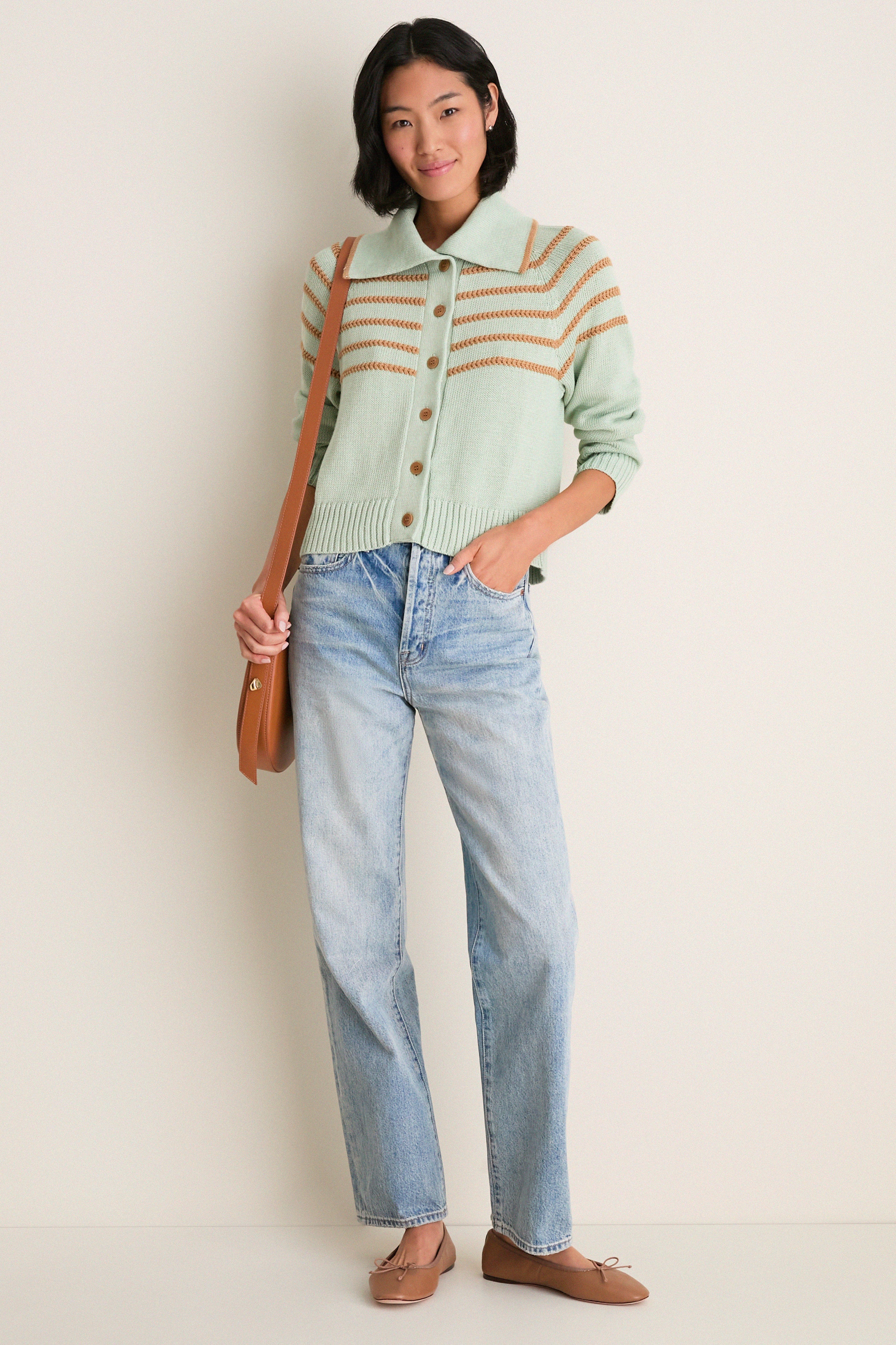 Woman in Seafoam Scholar Cardigan with Crochet Stripes, buttoned, paired with light-wash jeans, modeling a classic, high-end, effortless look with fun, relaxed elegance.
