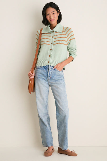 Woman in Seafoam Scholar Cardigan with Crochet Stripes, buttoned, paired with light-wash jeans, modeling a classic, high-end, effortless look with fun, relaxed elegance.
