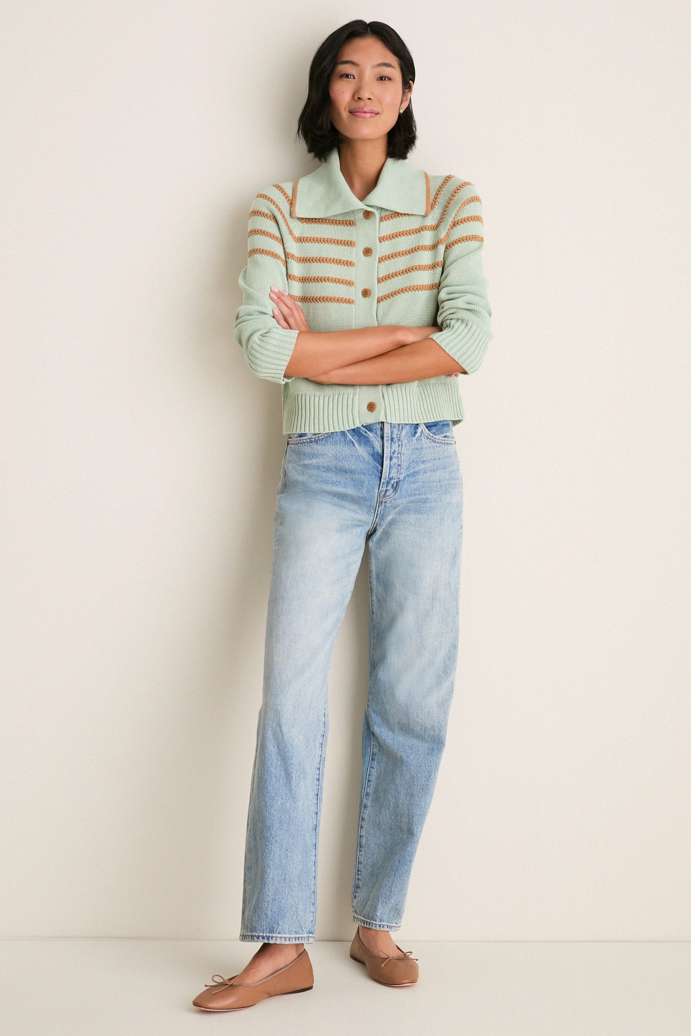 Young woman models the Seafoam Scholar Cardigan with crochet stripes, paired with straight-leg jeans and ballet flats, exuding a classic, effortless, and high-end style.
