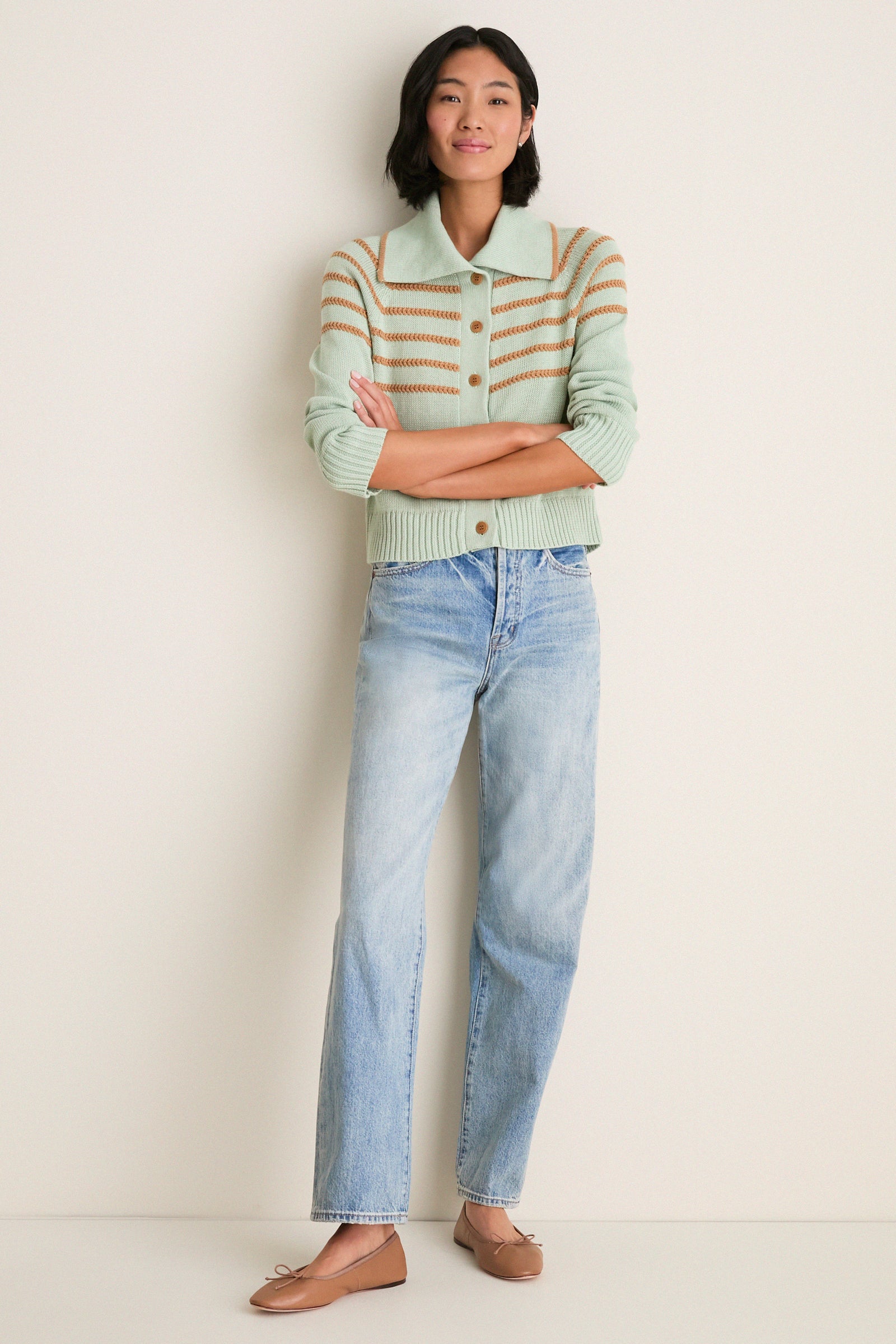 Young woman models the Seafoam Scholar Cardigan with crochet stripes, paired with straight-leg jeans and ballet flats, exuding a classic, effortless, and high-end style.