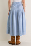The Chambray Embroidered Highland Skirt paired with cowboy boots exudes classic, effortless style, blending fun western inspiration with high-end, refined details like gentle pleats and floral embroidery.