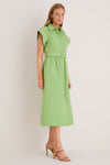 Woman in a classic, high-end Pistachio Chloe Dress with a collared, sleeveless design, cinched waist, and strappy sandals, embodying effortless and fun style.