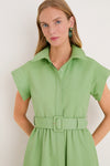 Woman wearing the classic Pistachio Chloe Dress, a high-end, effortless shirtdress with a belt, pointed collar, and concealed placket, paired with green-accented drop earrings.