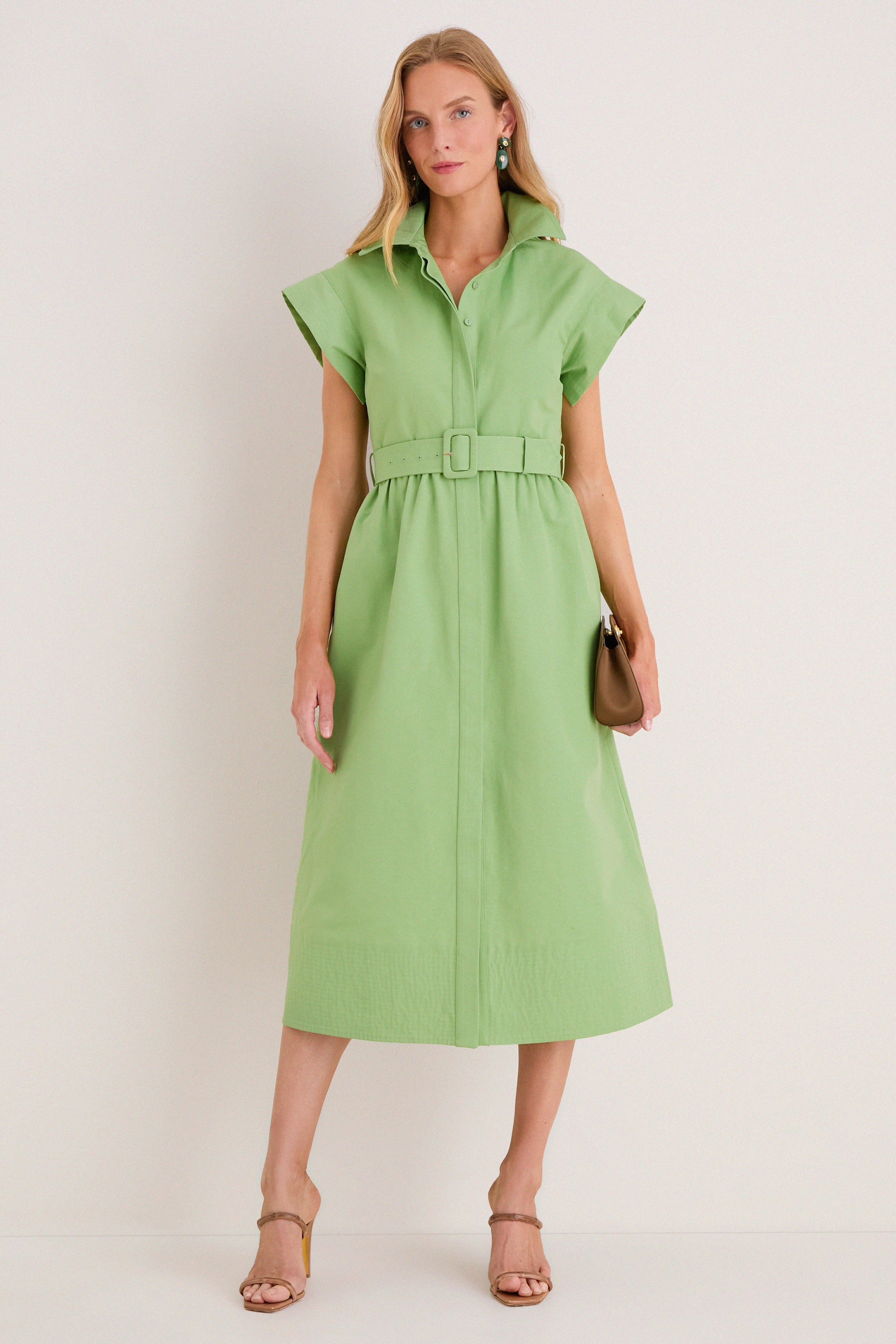 Female model in classic Pistachio Chloe Dress with effortless built-in belt, fun wing sleeves, and high-end brown sandals, exuding confidence and style against a simple backdrop.