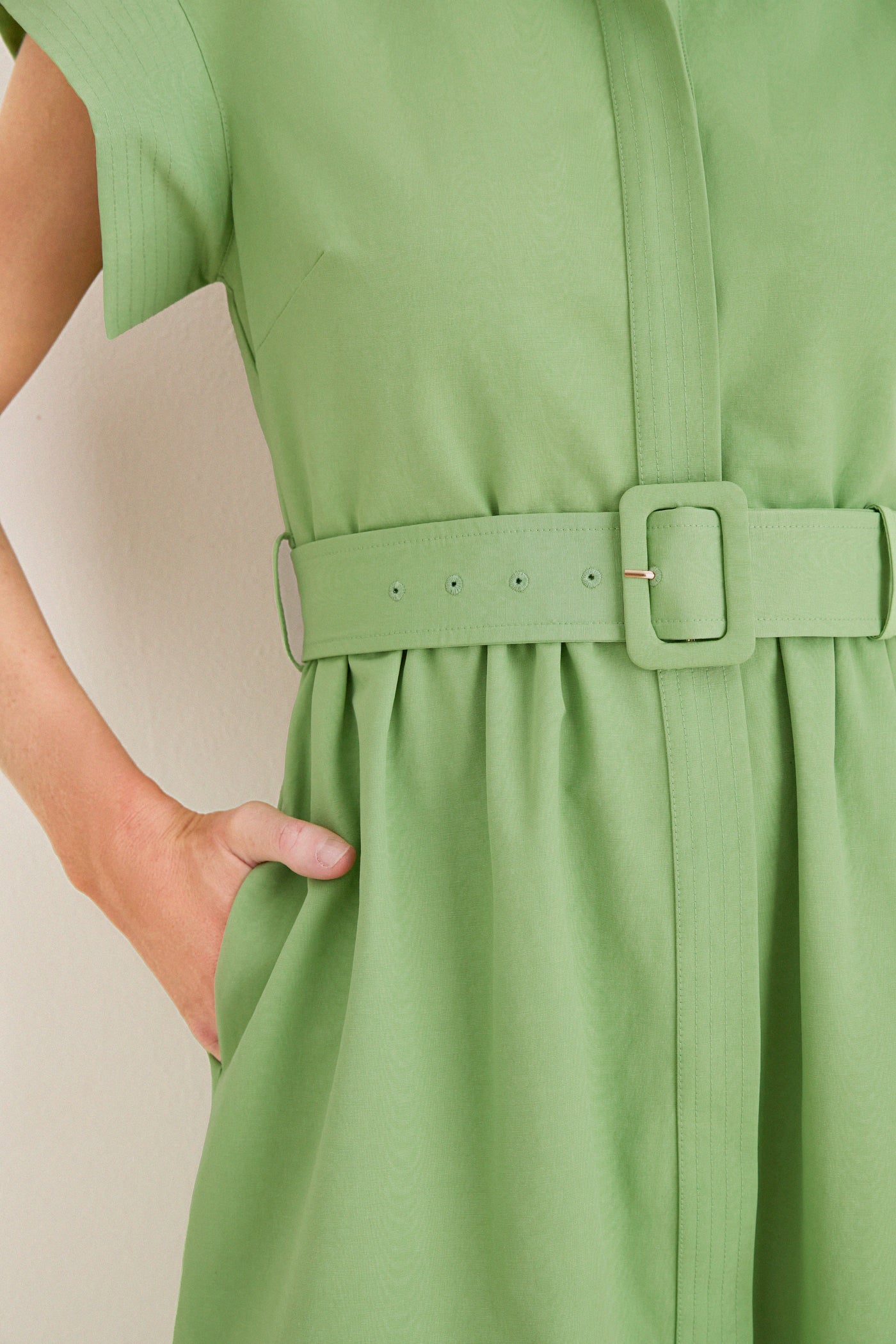Close-up of a classic, effortless Pistachio Chloe Dress with a textured cotton-blend, featuring a belt and pocket, perfect for a fun, high-end style.