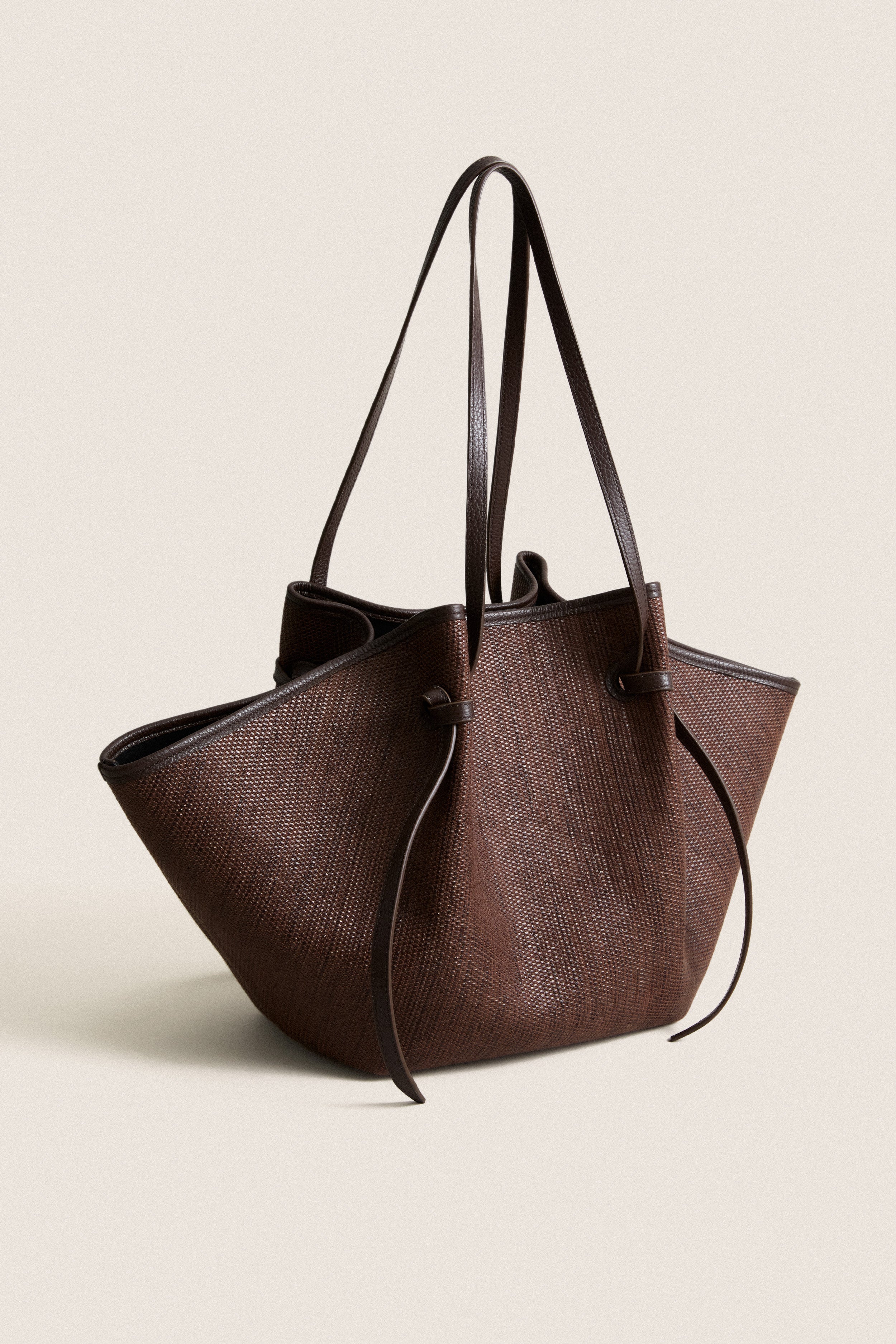 Fudge Large Woven Raffia Mochi Bag is a classic, high-end tote with knotted detailing, offering effortless style and fun for daily essentials and weekend plans.