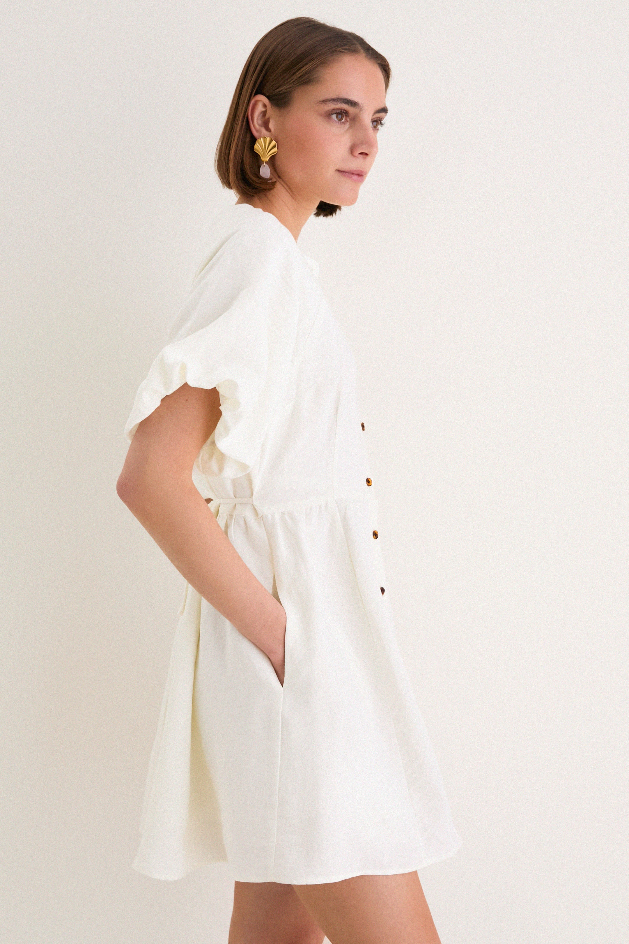 Young woman in profile wearing the classic, high-end Star White Bastille Short Dress with an effortless, feminine silhouette, perfect for fun, slow weekends.