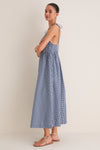Navy Gingham Sloan Maxi Dress: A classic and effortless ankle-length dress featuring tie straps and a smocked back, styled with fun tan sandals for a high-end look.