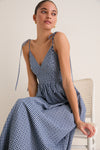 Navy Gingham Sloan Maxi Dress: A young woman in a classic, effortless gingham maxi dress with tie straps and a V-neckline, exuding high-end, fun sophistication.