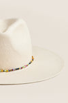 Classic and effortless, the White and Multi Charlotte Traveler Hat features a wide brim, pinched crown, and fun, high-end beaded trim, perfect for sunny adventures.