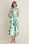 Woman in a classic Saffier Vines Zoey-E Midi Dress, featuring effortless green floral print, V-neck, button-front, and patch pockets; paired with open-toe mules.