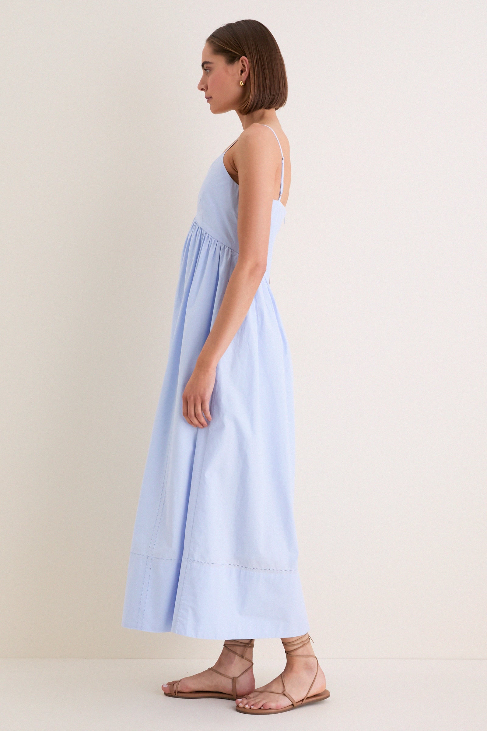 The French Blue Peninsula Dress showcases an effortless, high-end style with its fitted bust, relaxed tiered skirt, and adjustable straps—perfect for a classic, fun look.