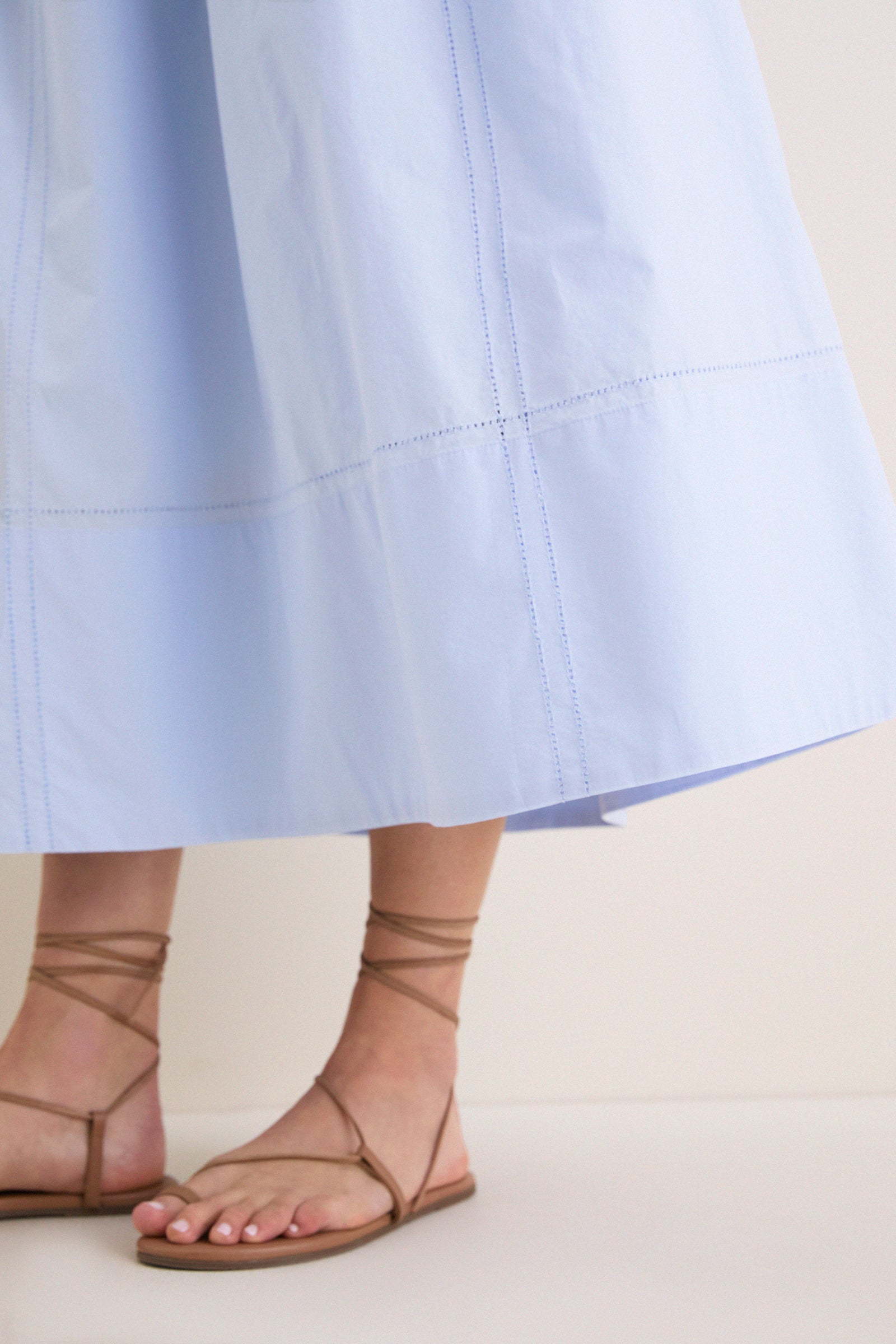 French Blue Peninsula Dress with hem-stitched details, showcasing effortless elegance and classic style. Worn with tan lace-up sandals, embodying high-end, fun sophistication.