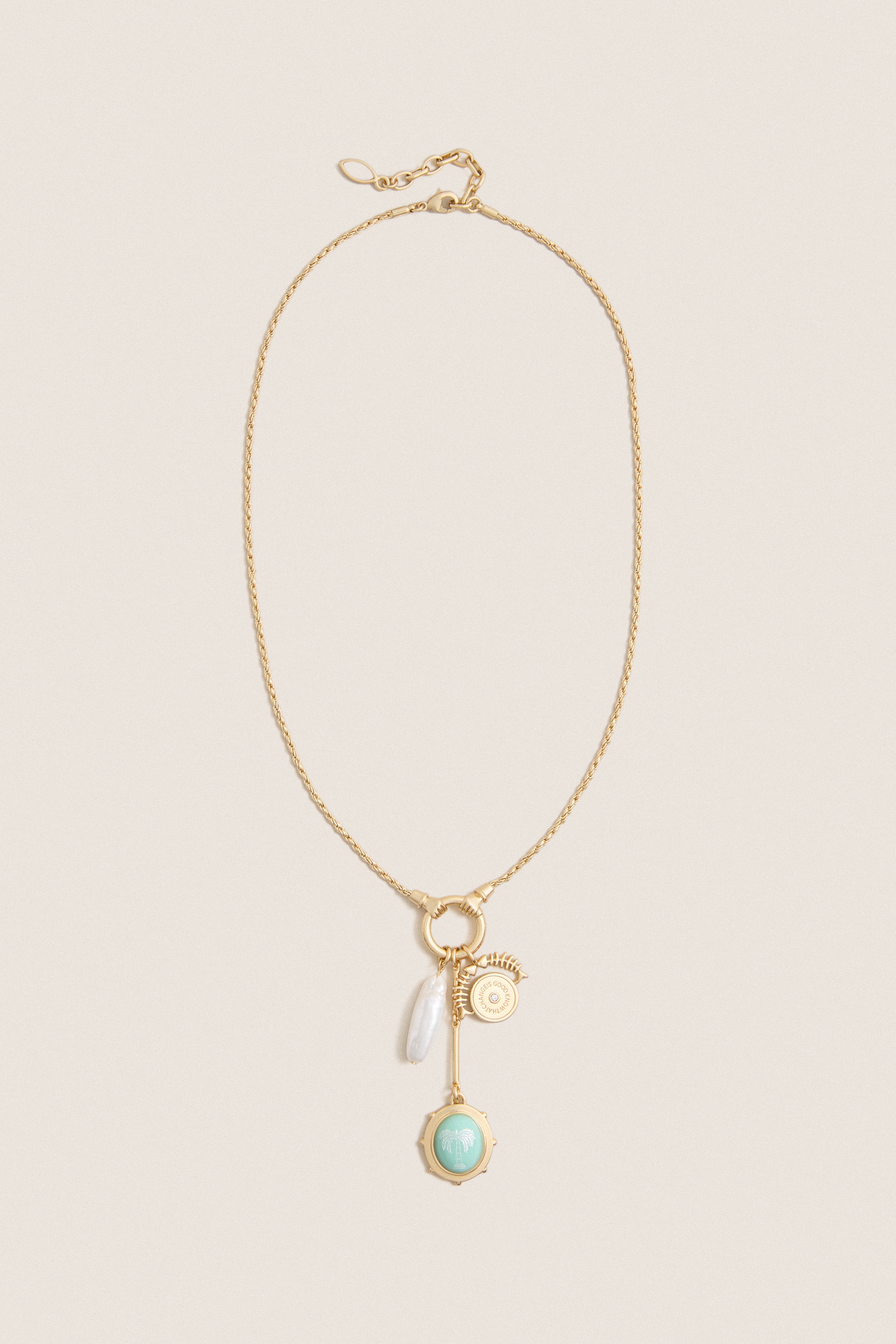 Gold Multi Frances Charm Necklace features a classic gold-tone chain with charms including a pearl drop, gold medallion, bar pendant, and mint-green palm-tree charm, offering effortless, high-end elegance.