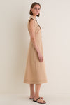 Young woman in profile wearing a classic Khaki Orla Dress with a modern notched collar, sleeveless design, and button-down front, paired with effortless black sandals.