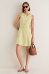 Young woman in a classic Pistachio Steiner Dress, featuring an effortless A-line silhouette, button placket, and chic accessories, embodying a high-end, fun summer style.