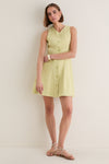 Young woman in classic Pistachio Steiner Dress, effortlessly styled with sandals and accessories, showcasing its high-end, fun A-line silhouette and button-down detail.