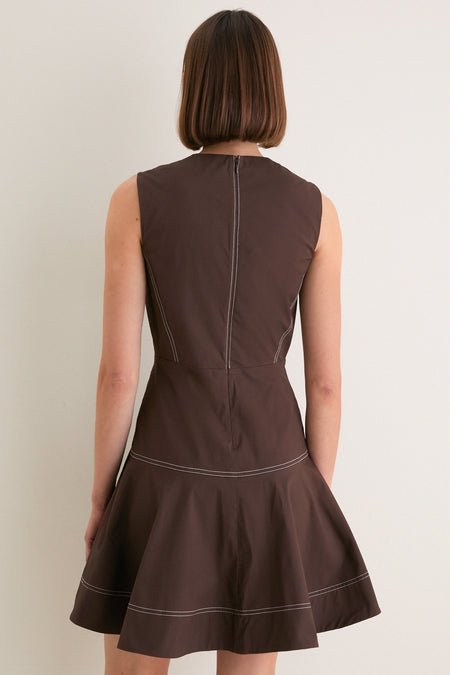 Person wearing the Dark Mocha Mini Karrigan Dress with a classic sleeveless fit-and-flare design, featuring effortless contrast stitching and a playful, high-end appeal.