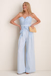 Model in Baby Blue De Tres Embellished Top, showcasing a classic strapless, pleated design with a sweetheart neckline and belt, paired with elegant high-waisted trousers.