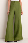 Model wearing Olive Green Vivir Pants, showcasing a classic, effortless high-waisted, wide-leg style with modern contrast stitching. Paired with black sandals for a high-end, fun look.