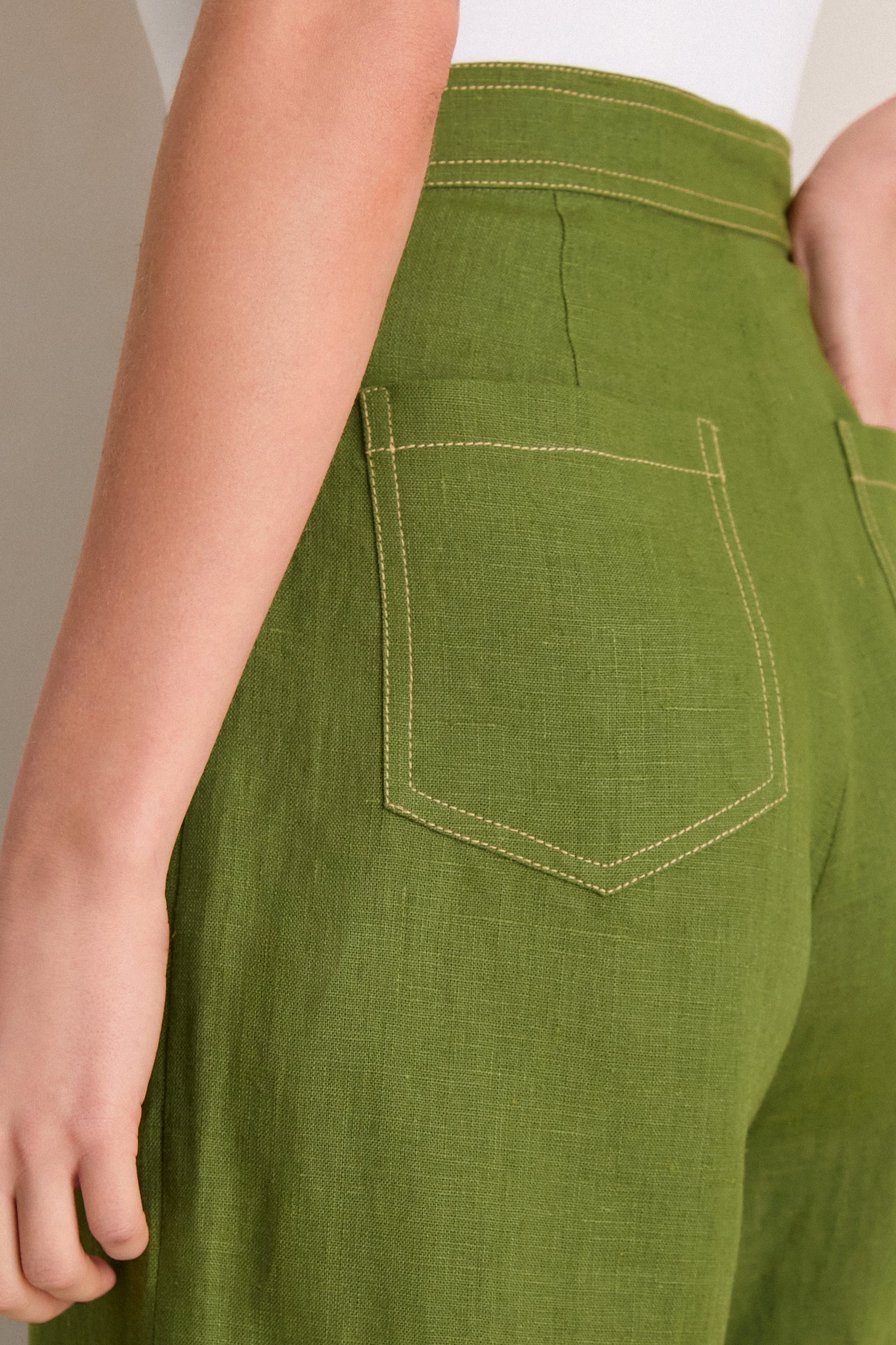 High-waisted Olive Green Vivir Pants in a classic, effortless style with wide legs and contrast stitching, showcasing a high-end, fun, and refined design.