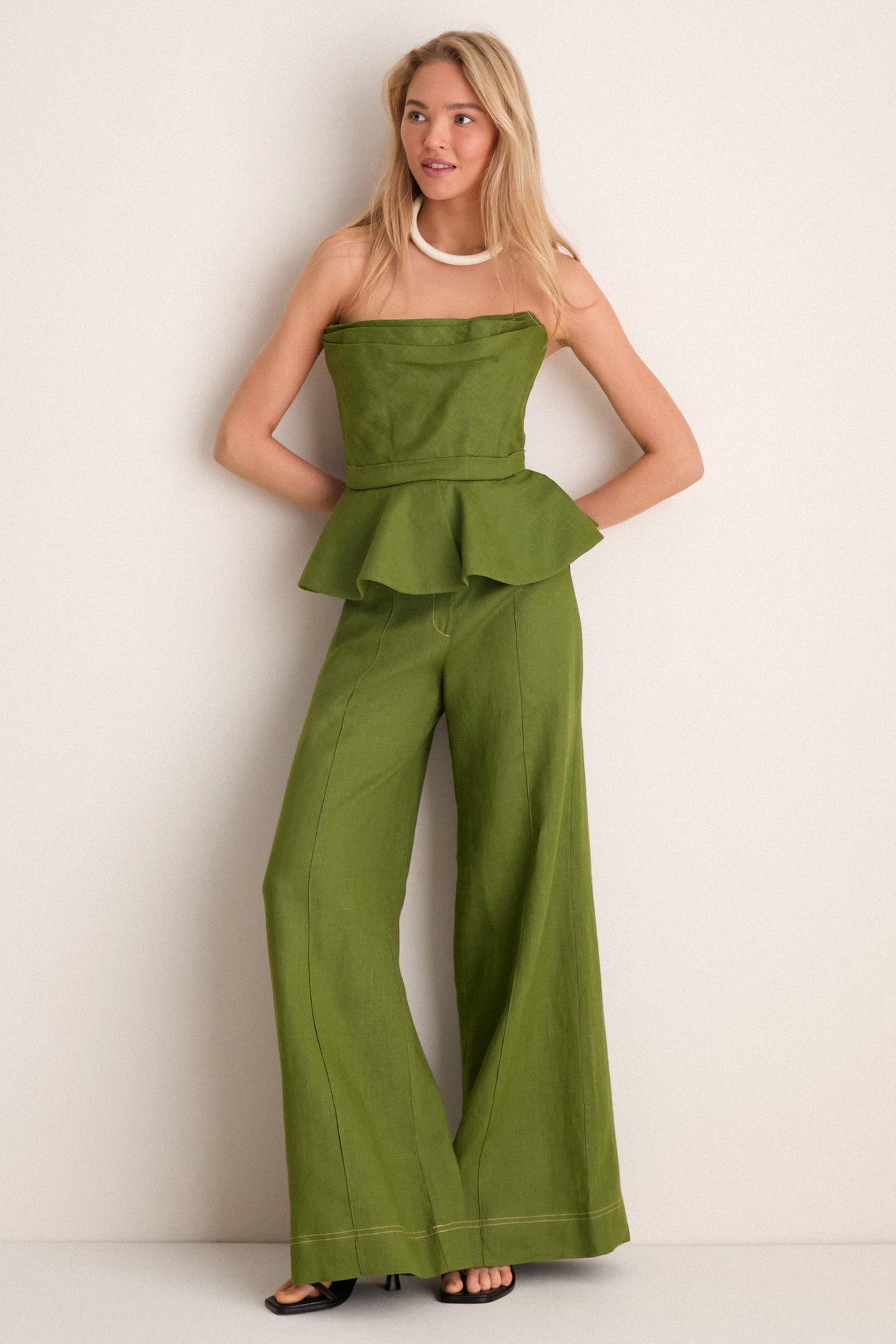Person wearing Olive Green Vivir Pants, showcasing a classic, high-waisted, wide-leg design. Paired with a matching top for an effortless, high-end, fun ensemble.
